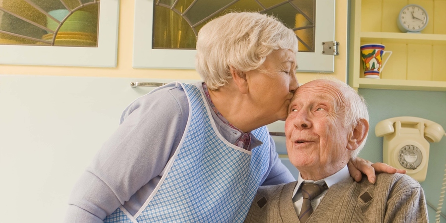 Vrouw geeft kus op voorhoofd van man Vrouw geeft kus op voorhoofd van man